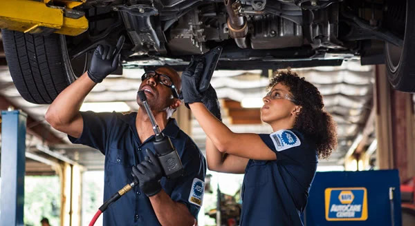 photo shows ASE mechanics repairing a car in a NAPA Auto Care Center